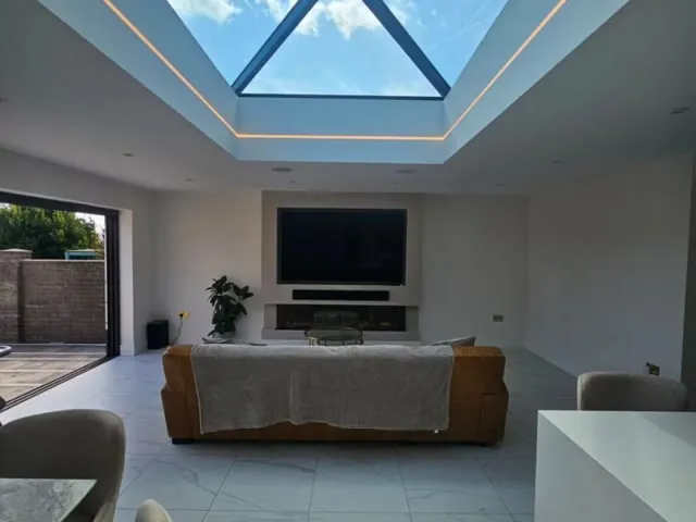A finished extension living room under a roof lantern by Build and Co